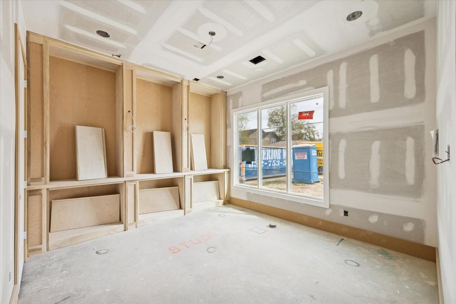 Dedicated first floor study framed by custom site built cabinetry and a large Low E window for natural light. Designed for focus and storage with recessed lighting and Level 4 smooth walls for a clean modern finish.