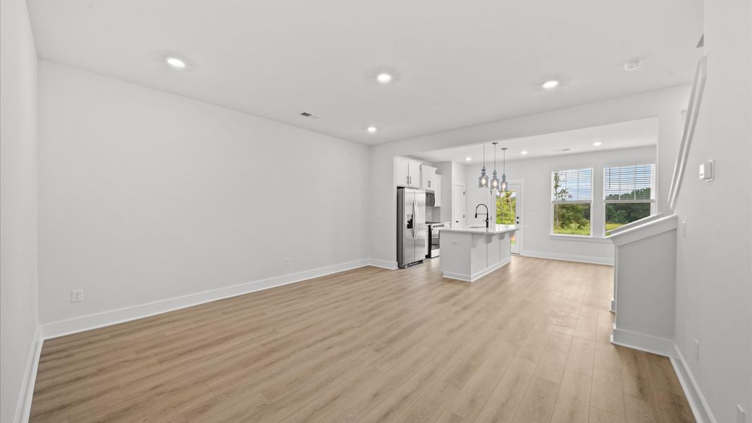 Elegant family room featuring hardwood flooring, large windows, and thoughtful architectural detail