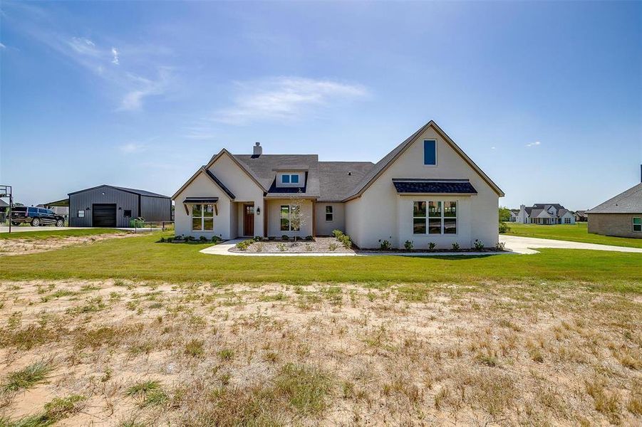View of front facade with a garage, a chimney, a front lawn, and stucco siding View of front facade with a garage, a chimney, a front lawn, and stucco siding