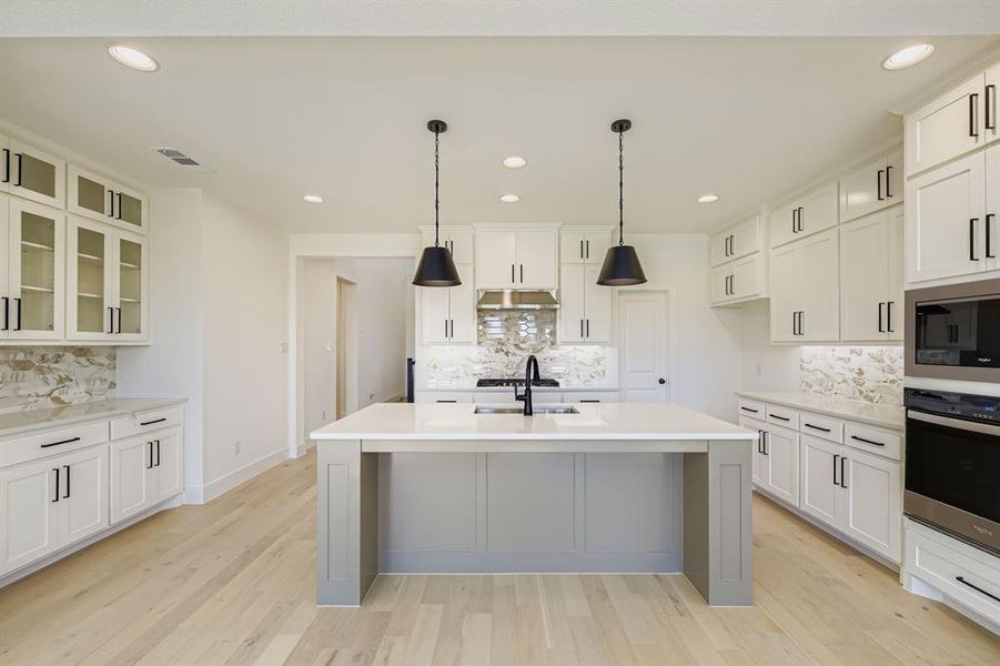 Kitchen with tasteful backsplash, recessed lighting, light countertops, and appliances with stainless steel finishes Kitchen with tasteful backsplash, recessed lighting, light countertops, and appliances with stainless steel finishes