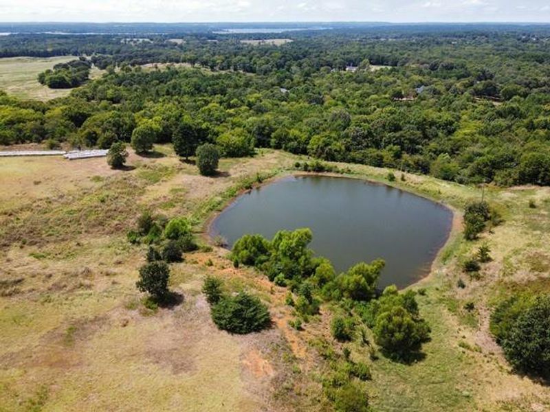 Aerial view of a nearby body of water and a heavily wooded area Aerial view of a nearby body of water and a heavily wooded area