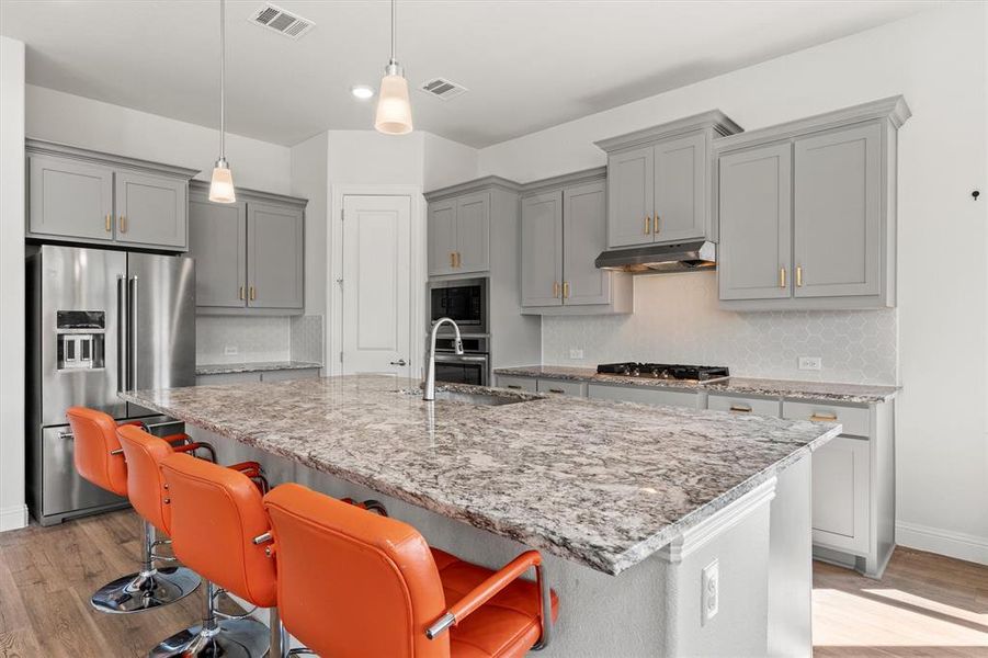 Kitchen features large island, granite countertops, ss appliances, and gas cooktop