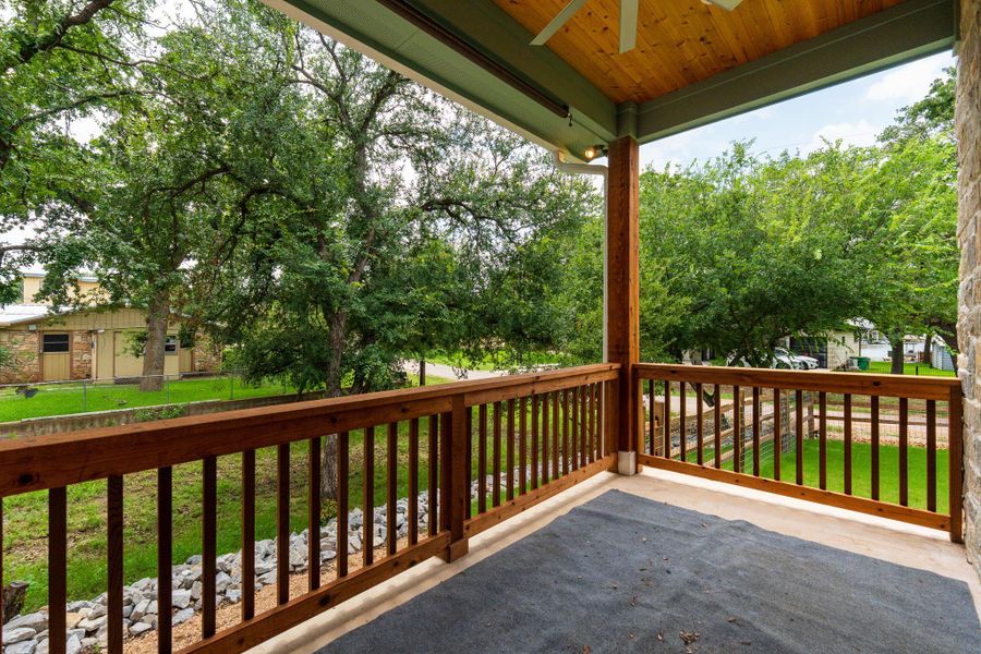 Enjoy outdoor living on this elevated covered deck, offering serene tree-lined vistas.
