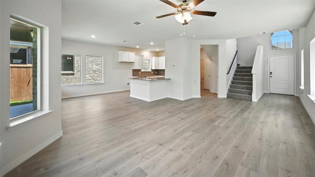Unfurnished living room with stairs, light wood-style floors, recessed lighting, and ceiling fan