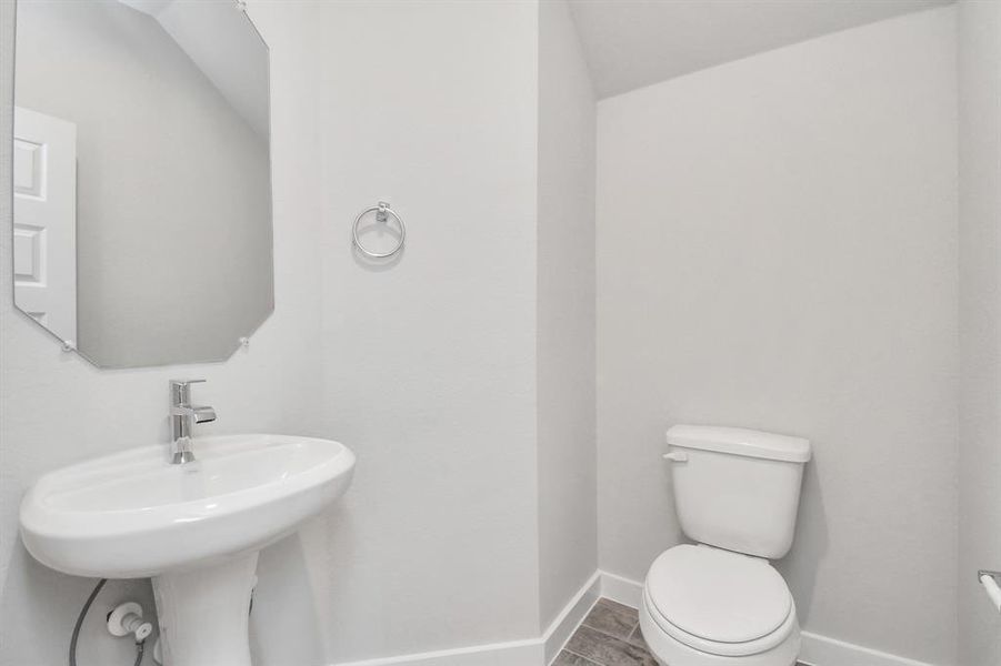 The half bathroom, conveniently situated on the 1st floor, is adorned with contemporary finishes. Sample photo of completed home with similar floor plan. As-built interior colors and selections may vary.