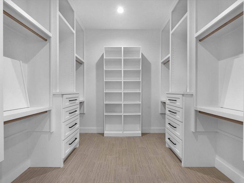 Primary bedroom closet with tons of custom shelving and cabinetry Primary bedroom closet with tons of custom shelving and cabinetry