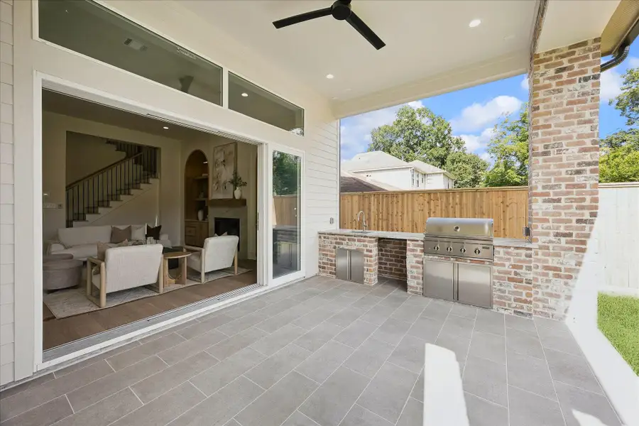 Open the folding glass wall and let the living space flow right outdoors. This covered summer kitchen creates a seamless connection between inside and out, making everything from weeknight grilling to weekend entertaining feel effortless.