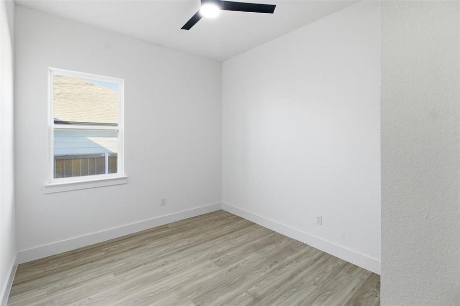 Spare room featuring light wood-style floors and a ceiling fan