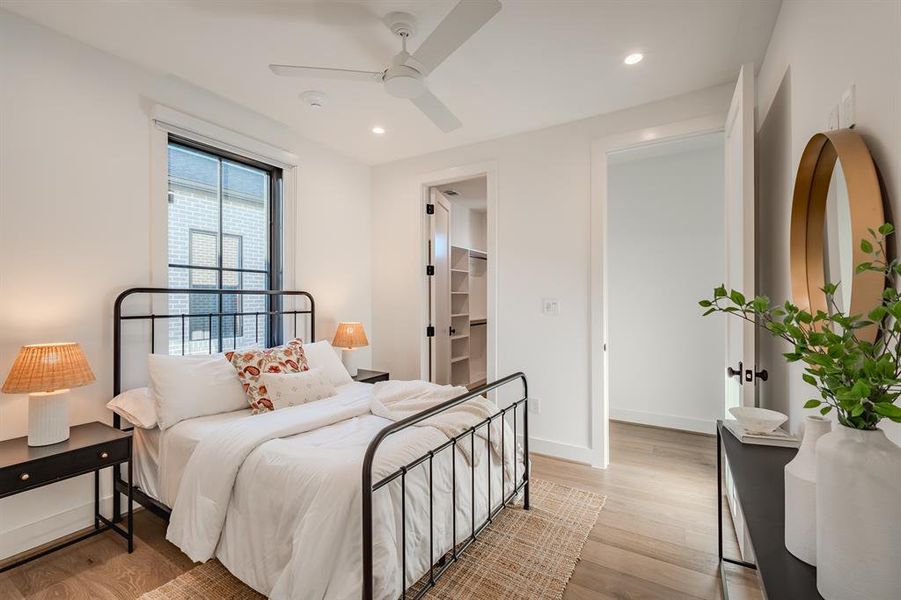Bedroom with a spacious closet, light wood-style floors, recessed lighting, and ceiling fan Bedroom with a spacious closet, light wood-style floors, recessed lighting, and ceiling fan