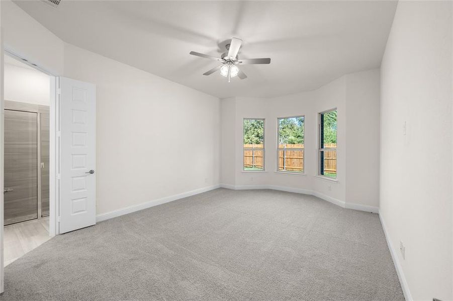 Unfurnished room featuring light colored carpet and a ceiling fan