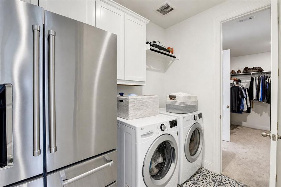 The laundry room, with space for a second fridge, conveniently connects to the walk-in closet in the primary bedroom.