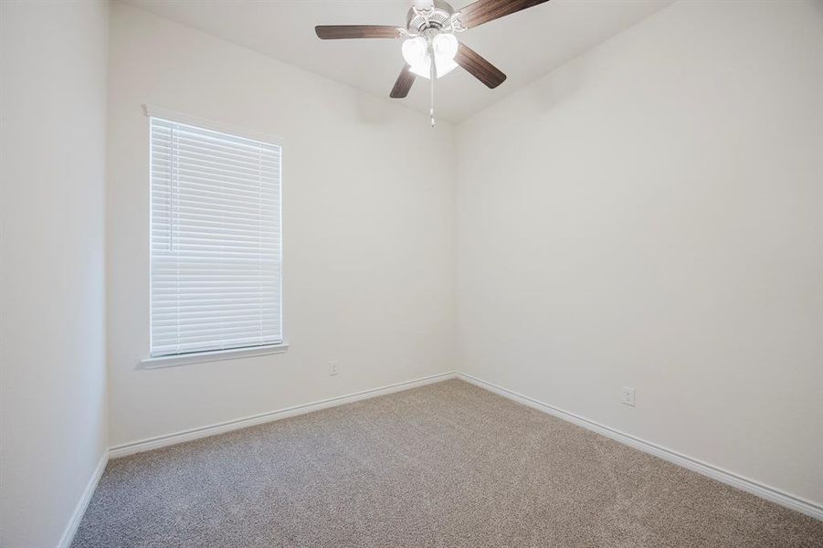 Carpeted spare room with ceiling fan