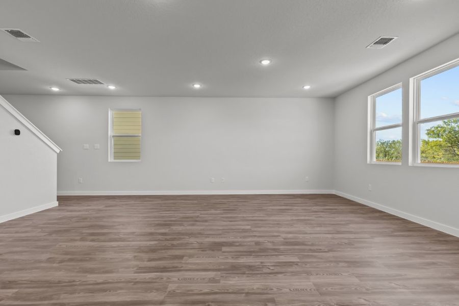 A room with a wood floor and windows. A room with a wood floor and windows.