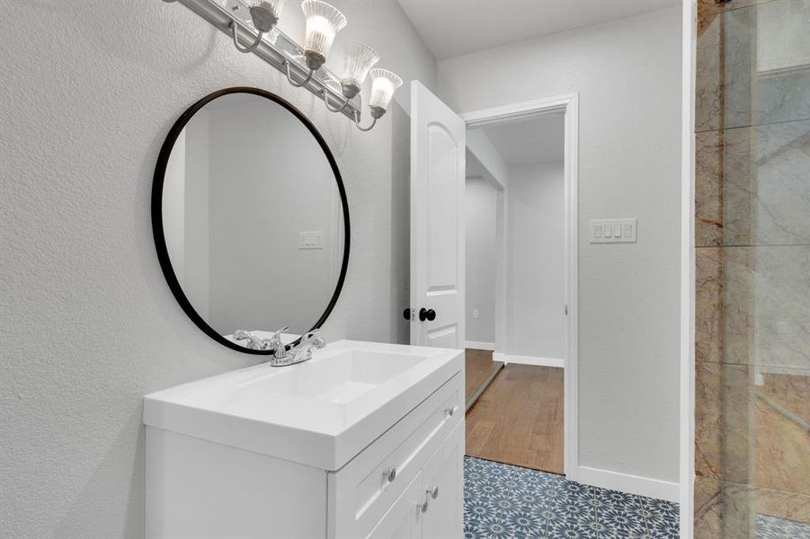 Upstairs jack and jill Bathroom with vanity, tile patterned floors, and baseboards