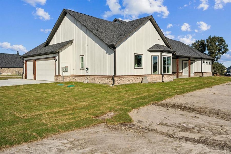 View of side of property with a lawn and a garage