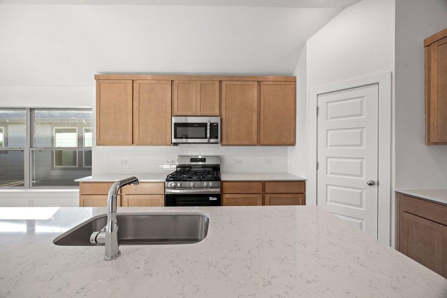 Modern kitchen with sleek counters and a convenient island sink for effortless meal preparation.