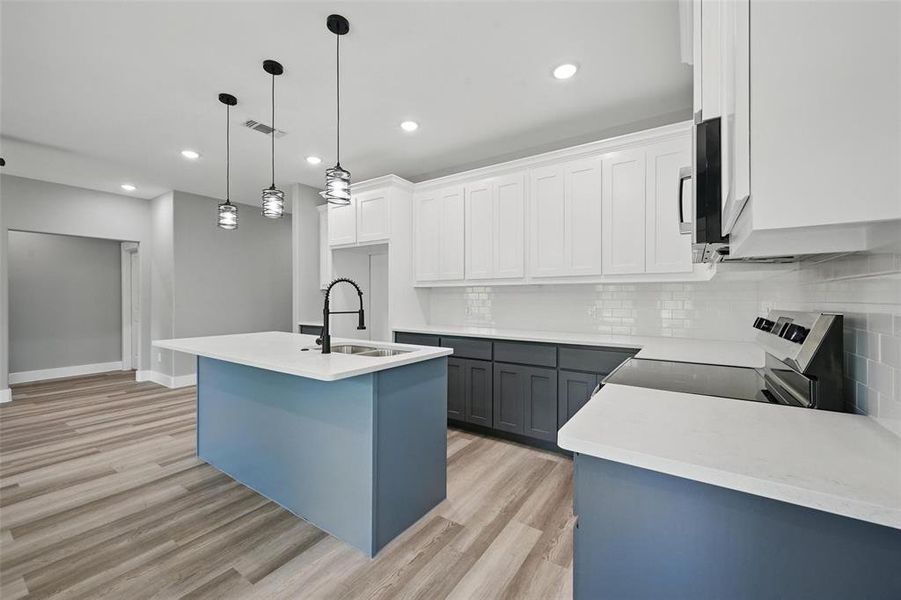 Kitchen featuring a sink, electric stove, light wood-type flooring, backsplash, and recessed lighting