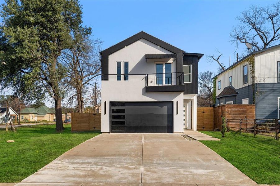Contemporary home with a balcony, stucco siding, driveway, and a garage Contemporary home with a balcony, stucco siding, driveway, and a garage