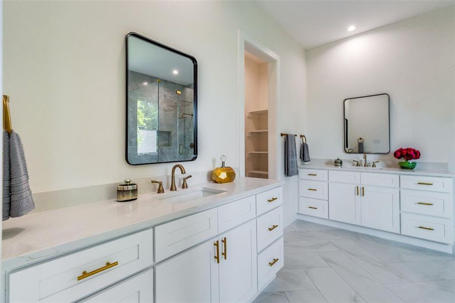 Bathroom featuring tile patterned flooring, a shower with door, and vanity