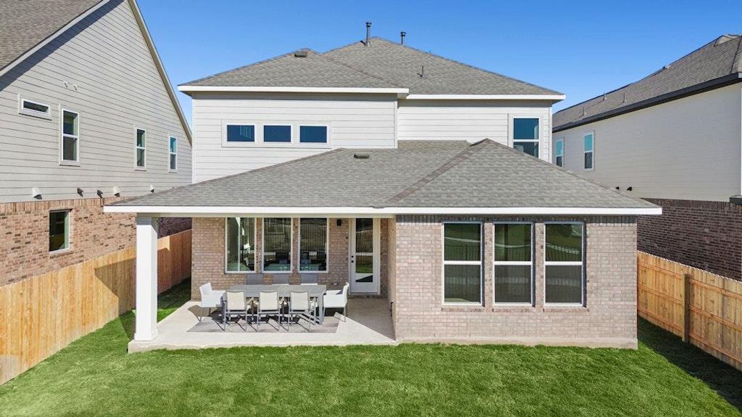 Back of property featuring a patio area, a shingled roof, and brick siding Back of property featuring a patio area, a shingled roof, and brick siding