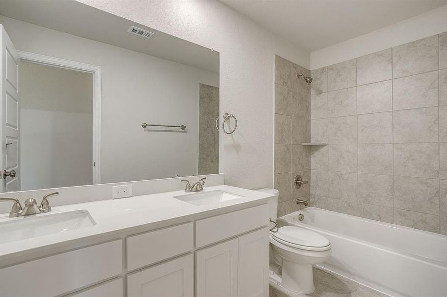 Bathroom featuring washtub / shower combination and double vanity