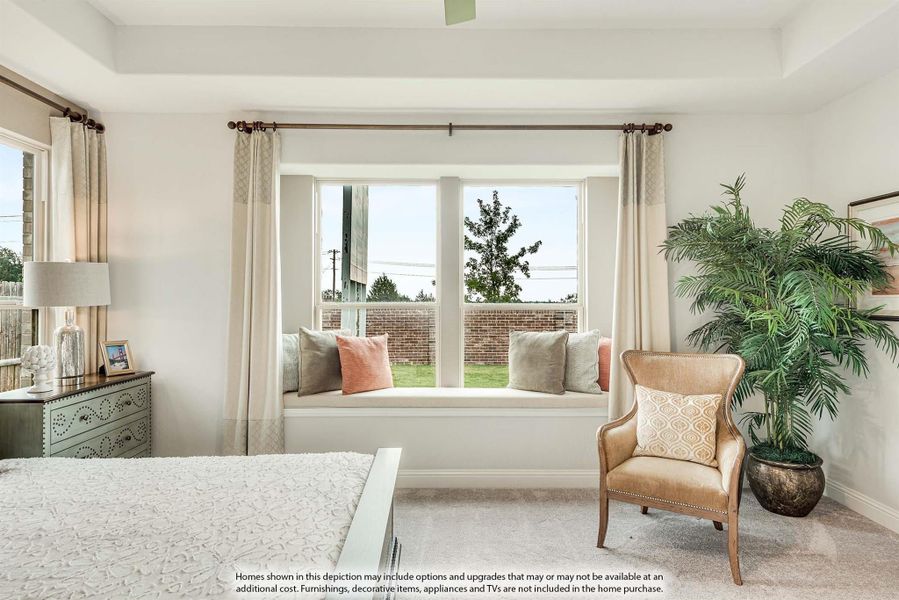 Bedroom with tray ceiling, window seat with cushions, accent chair, and large windows with drapes