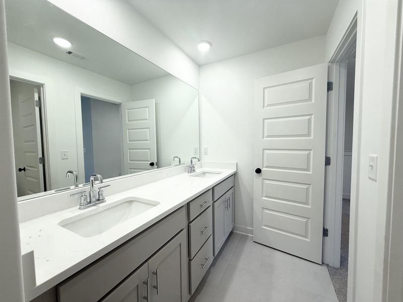 Bathroom with double vanity and recessed lighting