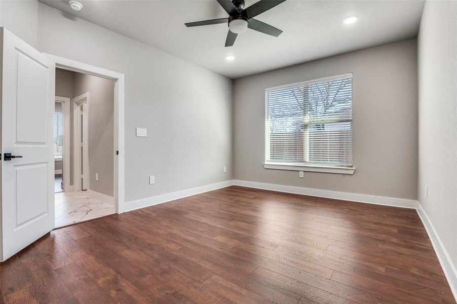 Spare room featuring healthy amount of natural light, dark wood-style floors, a ceiling fan, and recessed lighting