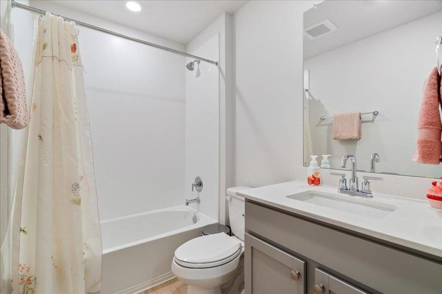 Bathroom featuring vanity, recessed lighting, toilet, visible vents, and shower / bath combo
