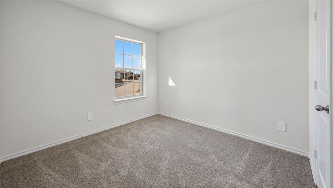 Neutral wall paint, gray carpet flooring, white trim, and a white interior door with a matte gray handle