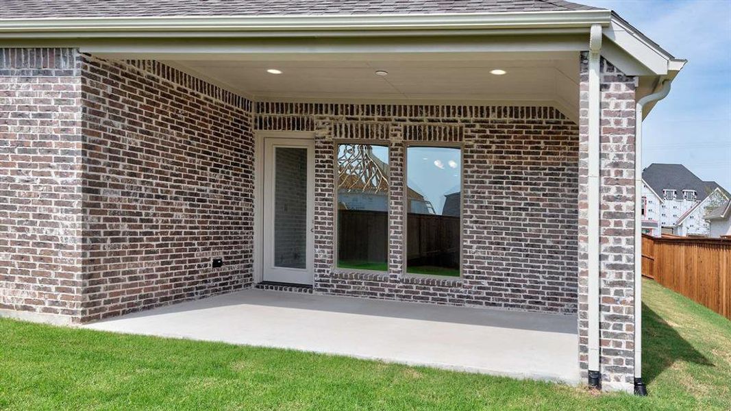 Doorway to property featuring a patio area and a yard