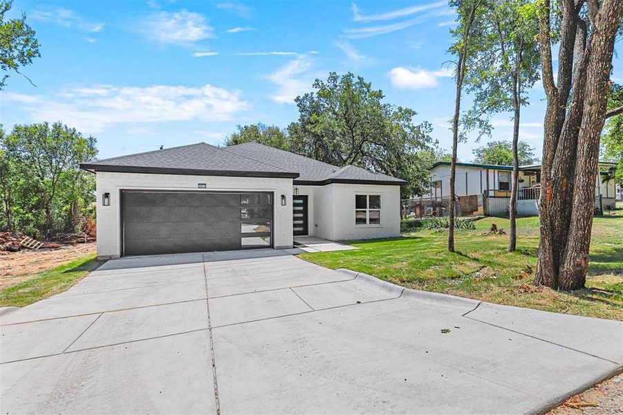 Single story home featuring a garage and a front lawn