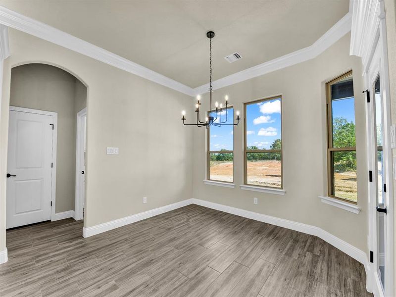 Unfurnished dining area with a notable chandelier and ornamental molding