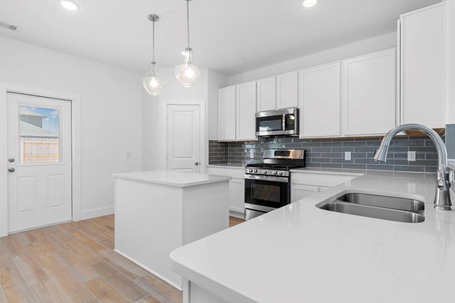 This bright and inviting gourmet kitchen features a spacious center island, ideal for meal prep, serving snacks, or enjoying a quick bite. With its clean design, modern pendant lighting, and open access to the backyard and main living areas, this kitchen is truly the heart of the home. This bright and inviting gourmet kitchen features a spacious center island, ideal for meal prep, serving snacks, or enjoying a quick bite. With its clean design, modern pendant lighting, and open access to the backyard and main living areas, this kitchen is truly the heart of the home.