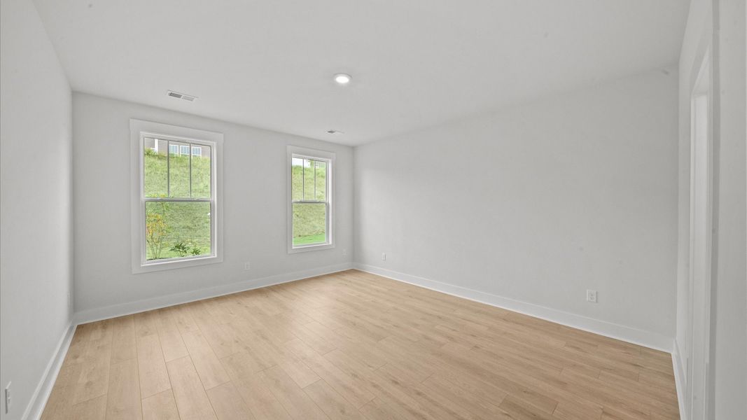 Vibrant natural light fills this exceptional primary suite with eye-catching details