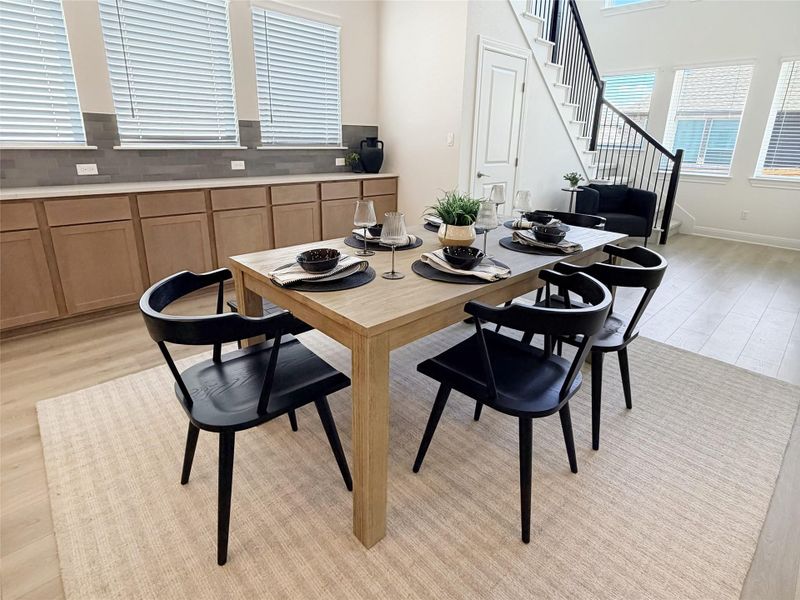 Dining area featuring light wood-style flooring and a high ceiling