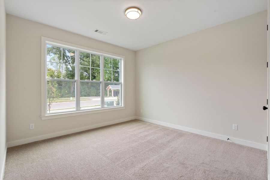 Neutral tone wall paint, carpeted flooring, large multi-pane window, flush mount ceiling light fixture, and white trim Neutral tone wall paint, carpeted flooring, large multi-pane window, flush mount ceiling light fixture, and white trim