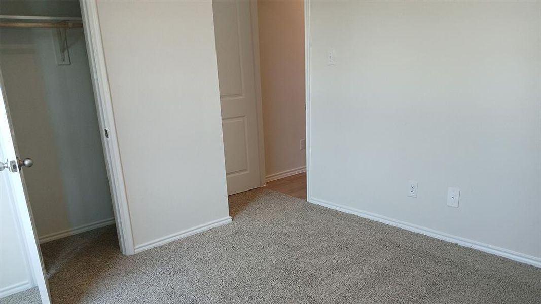 Light beige wall-to-wall carpeting throughout this space, featuring white baseboards and trim Light beige wall-to-wall carpeting throughout this space, featuring white baseboards and trim
