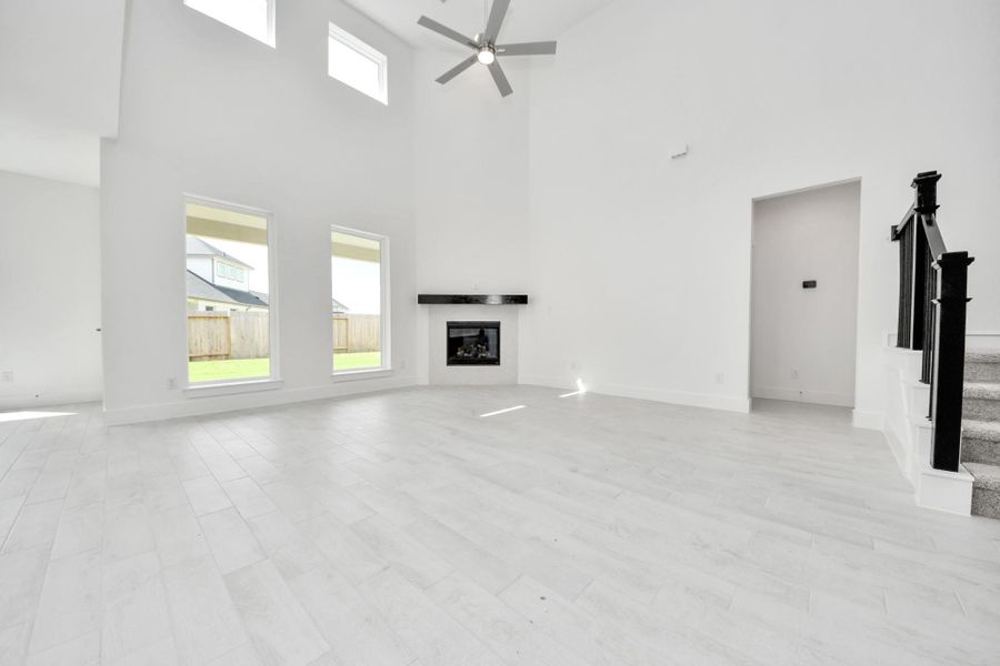 Family room flooded with natural light through the expansive windows. The premium tile flooring adds a touch of luxury to the space, creating the perfect setting for relaxing moments and cherished gatherings with loved ones. Family room flooded with natural light through the expansive windows. The premium tile flooring adds a touch of luxury to the space, creating the perfect setting for relaxing moments and cherished gatherings with loved ones.