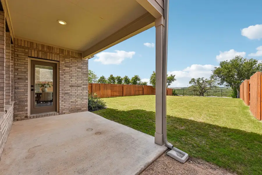 A spacious backyard with a private fence, verdant lawn, and a covered patio for outdoor enjoyment.