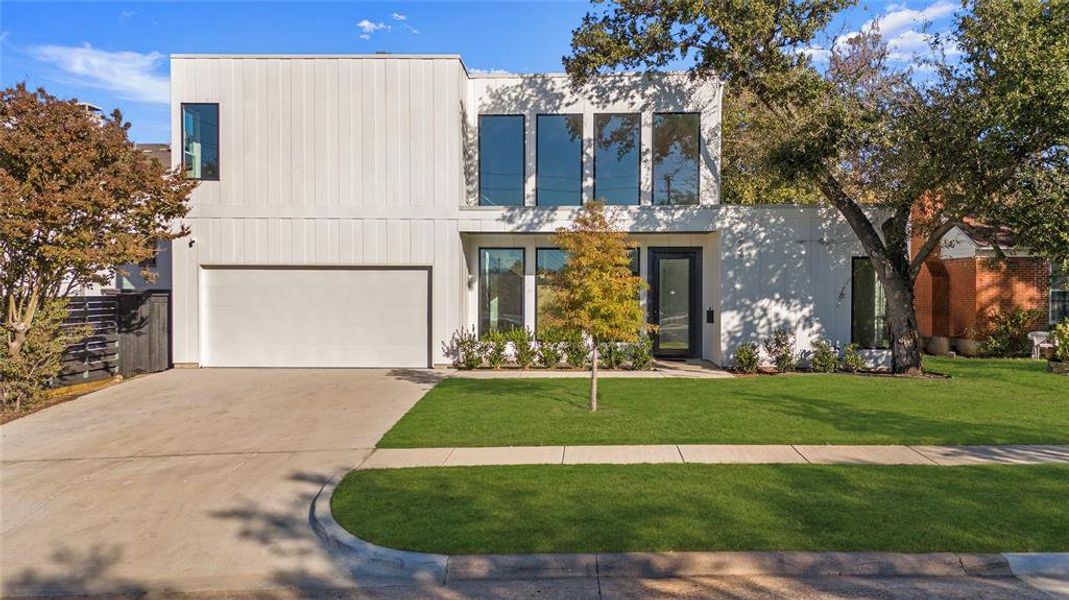 Contemporary house featuring a front lawn and a garage