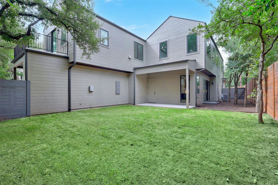 Back of house with a patio area, a fenced backyard, and a balcony Back of house with a patio area, a fenced backyard, and a balcony