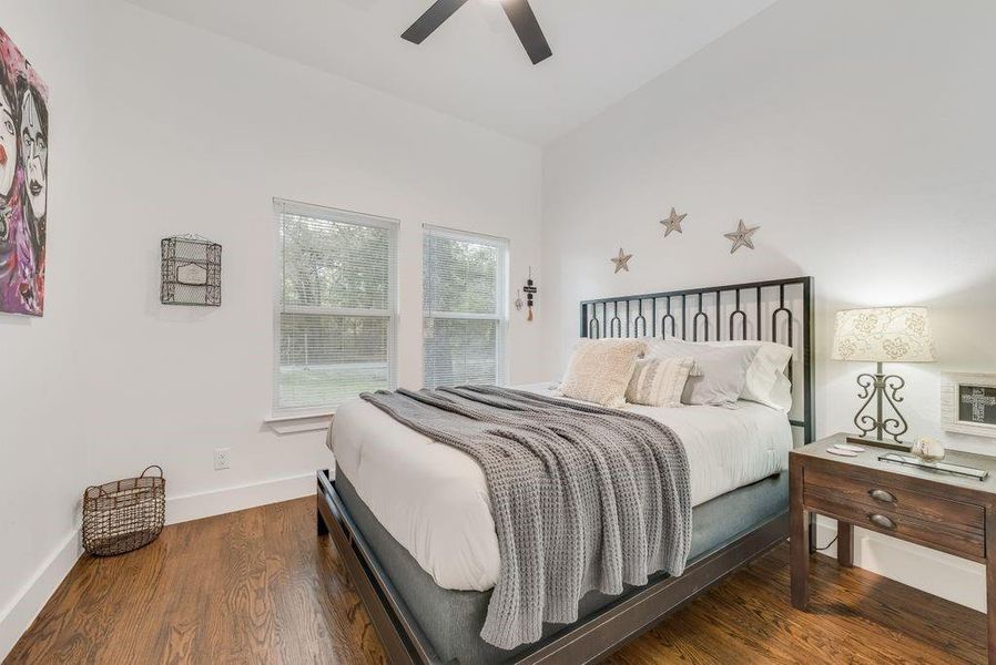 Bedroom with wood finished floors, a ceiling fan, and vaulted ceiling