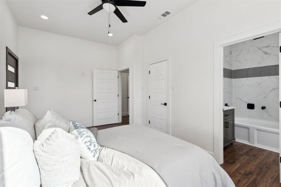 Bedroom featuring a ceiling fan and the ensuite bathroom. Bedroom featuring a ceiling fan and the ensuite bathroom.
