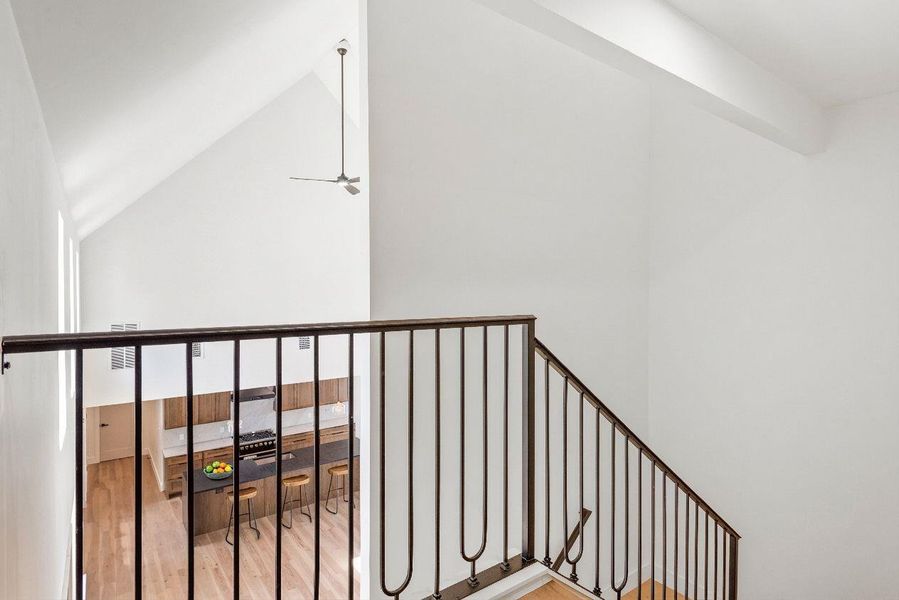 From the top of the stairs, the living room and kitchen stretch out beneath, inviting a downward glance.