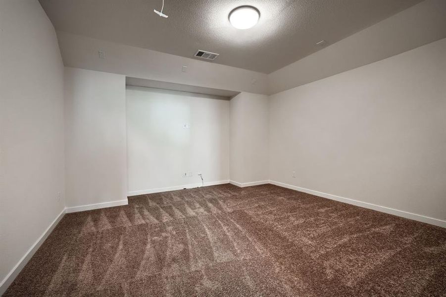 Empty room with carpet flooring and a textured ceiling