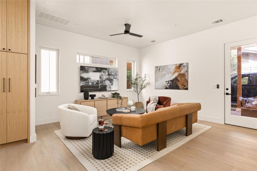 Living room with light wood-style floors and ceiling fan