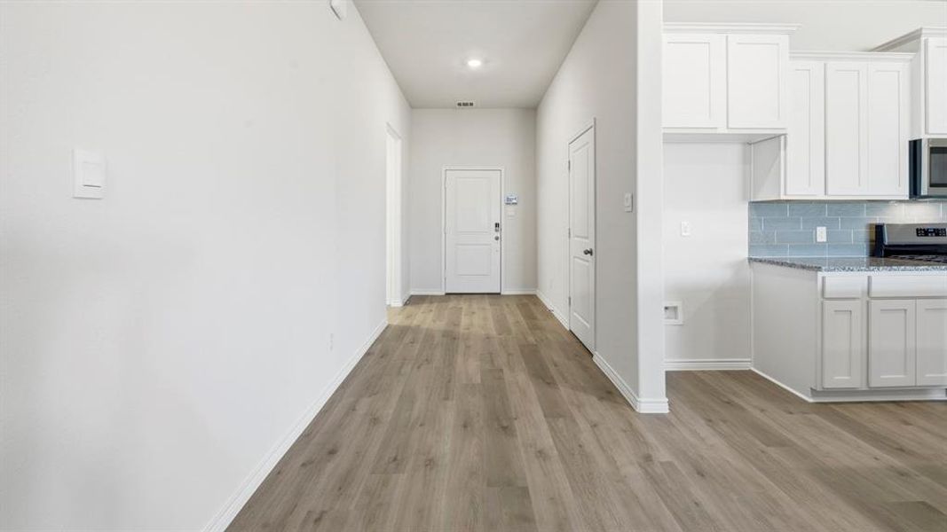 Corridor with baseboards and light wood-style floors