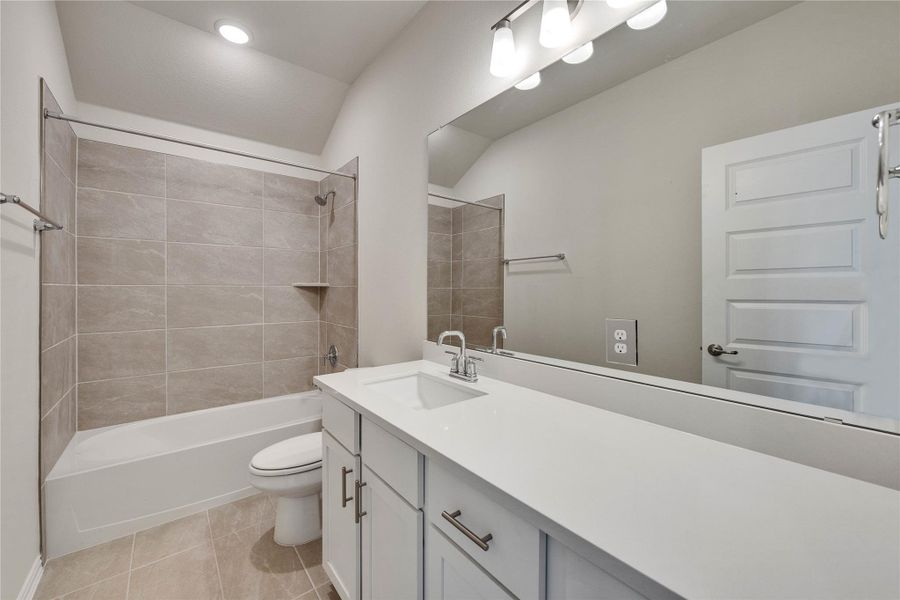 Full bath featuring vanity, washtub / shower combination, and tile patterned flooring Full bath featuring vanity, washtub / shower combination, and tile patterned flooring