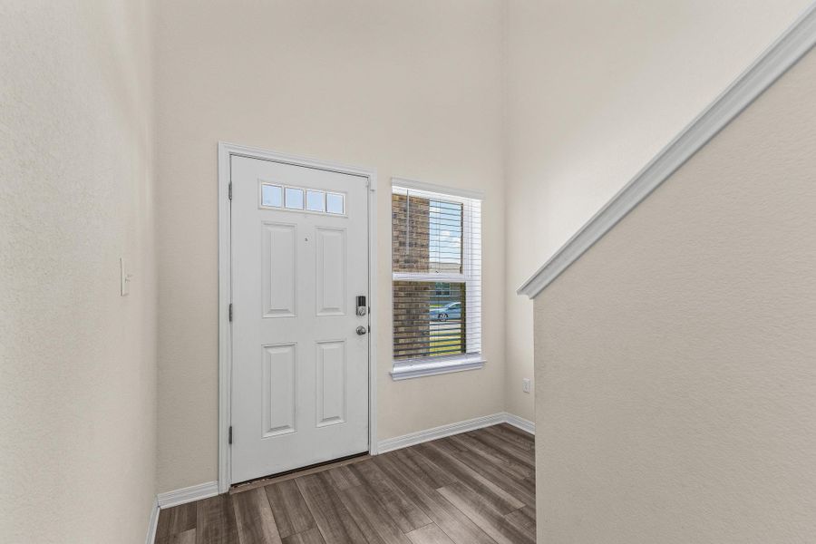 Foyer with wood finished floors and a textured wall Foyer with wood finished floors and a textured wall